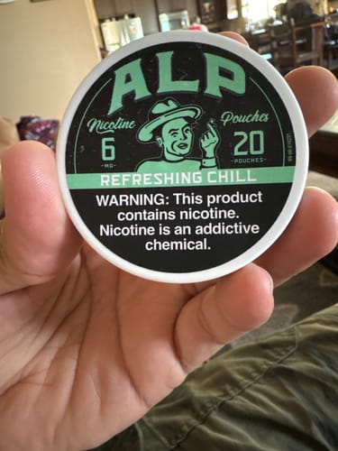 Customer's hand holding a circular Refreshing Chill nicotine pouch container