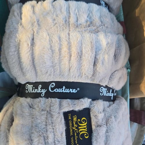 Customer's plush gray Hugs Tranquil Dove blanket, featuring the branded Minkys label, folded close-up.