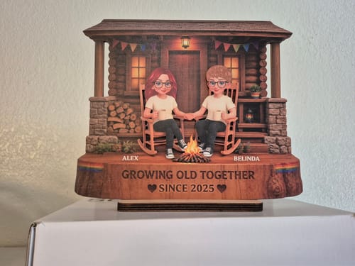 Customer's personalized LGBT+ wooden plaque, showing a couple sitting on a porch with the text Growing Old Together.