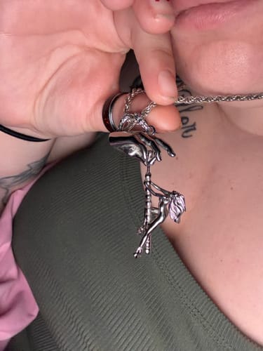 Customer's silver Dancing With Death pendant held by a hand, showing the detailed figure and hanging design.