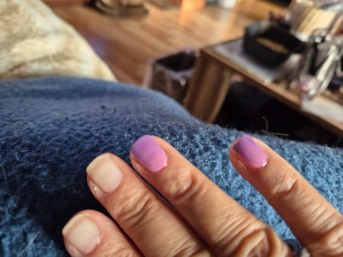 Customer's hand showing applied UV Gel Dancing Till Dawn nail wraps with a pink-purple ombre color.