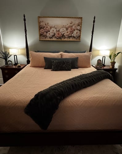 Customer's charcoal Hugs Blanket draped across a made bed in a bedroom.