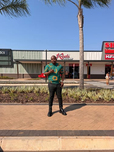 Customer's LFN014B knit top in green, worn by a person standing outside in a parking lot.