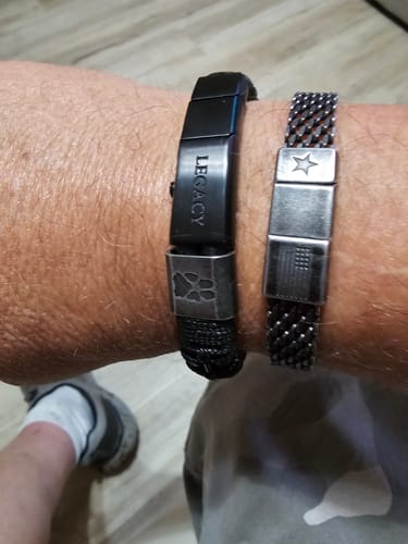 Customer's black stainless Loyal Friend Morse Code Legacy Urn Bracelet worn on their wrist alongside another bracelet.