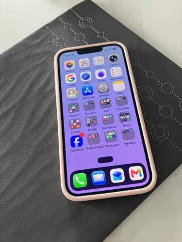Customer's Apple iPhone 17e displaying the home screen with app icons, resting on a dark patterned surface.