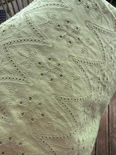 Customer's close-up view of sage green Cotton Broderie Anglaise fabric showing detailed floral embroidery pattern.