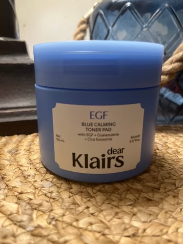 Customer's blue Klairs EGF Blue Calming Toner Pad jar sitting on a textured woven surface.