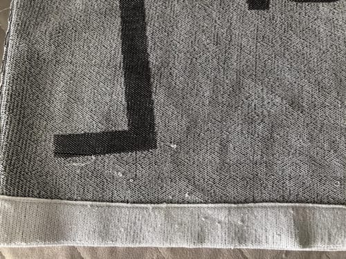 Customer's LFN014B knit top close-up, showing frayed threads and loose stitching on the fabric.