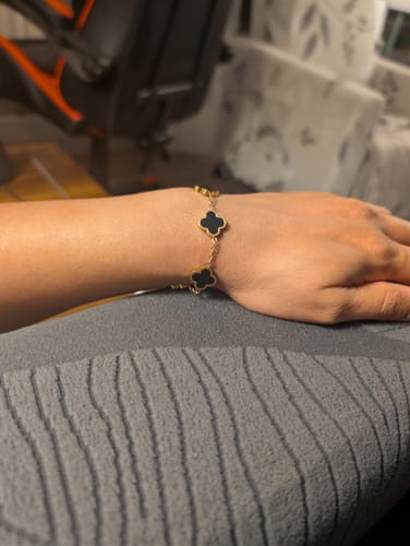 Customer's gold-toned Black Clover Bracelet with black clover charms worn on a person's wrist.