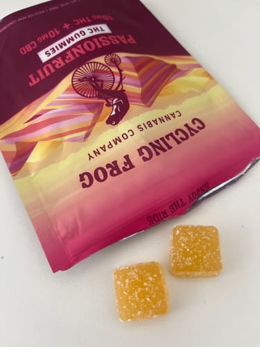 Customer's Passionfruit Gummies bag opened with two orange, square-shaped gummies sitting on a white surface.