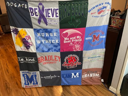 Customer's Project Repat T-Shirt Quilt displayed, featuring various colorful fabric squares with printed logos and text.