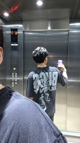 Customer's Looney Tunes Vintage Tee seen in a mirror reflection, featuring a large graphic design on the back.