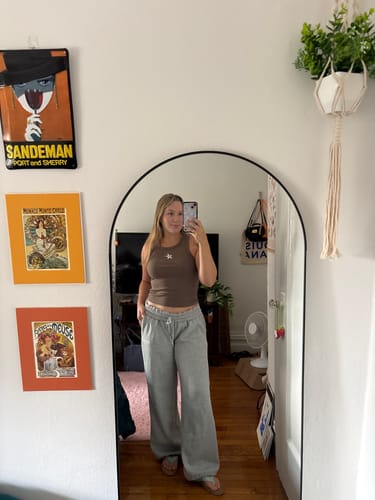 Reviewer in a mirror selfie wearing gray Streak Joggers and a brown tank top.