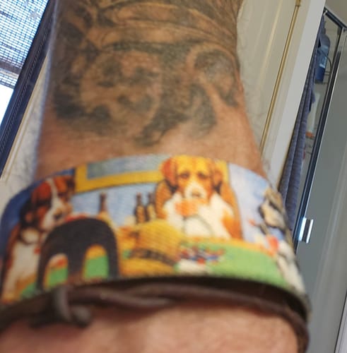 Customer's Doggone Lucky Bracelet worn on wrist, featuring a colorful design of dogs playing poker.