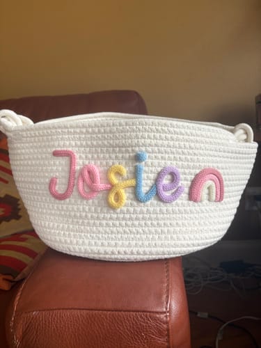 Customer's white woven basket with colorful yarn lettering spelling Josie and a rainbow.