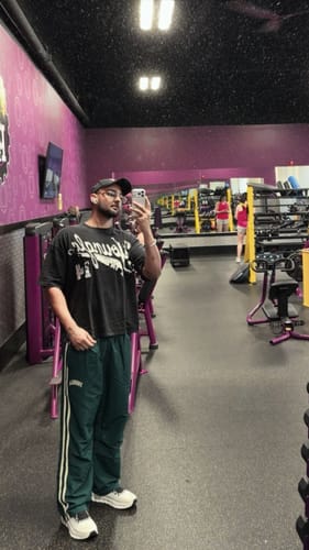 Customer's Distressed Script Tee worn by a person in a gym, showing the black oversized graphic T-shirt.