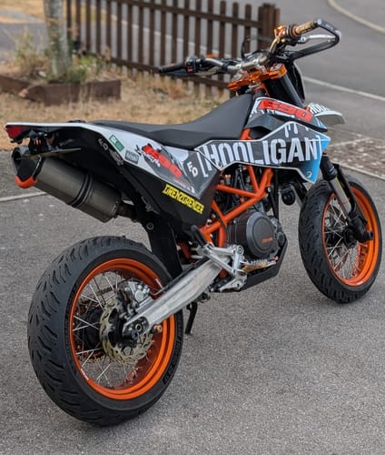 Customer's motorcycle with the Generic Bracket installed, shown in a paved outdoor area.