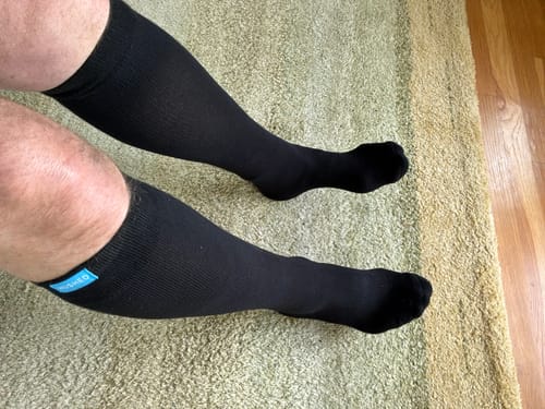 Reviewer's legs wearing black Eucalyptus Lyocell Compression Socks with a visible light blue brand label.