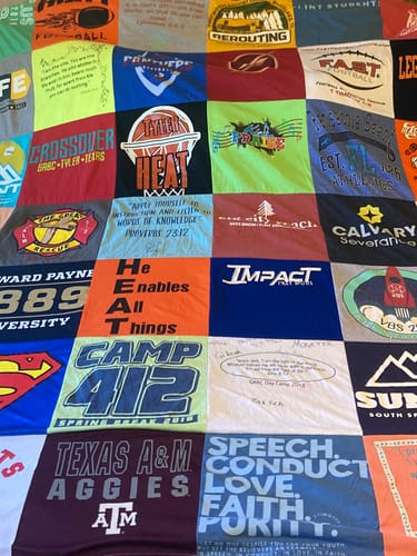 Customer's Project Repat T-Shirt Quilt featuring various colorful t-shirt squares with sports and team logos.
