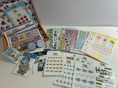Customer's Mystery Box contents featuring an assortment of colorful stickers, washi tapes, and stationery sheets.
