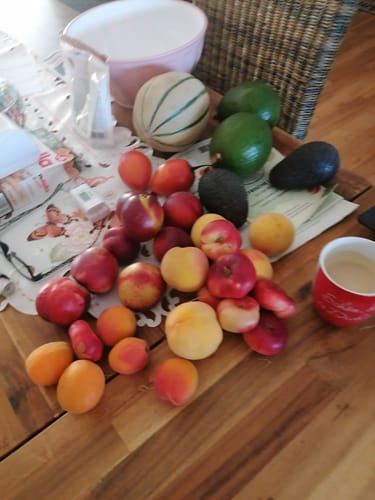 Customer's Steinobst-Mix Bio Sonnenküsse Box, featuring various fresh stone fruits on a wooden table.