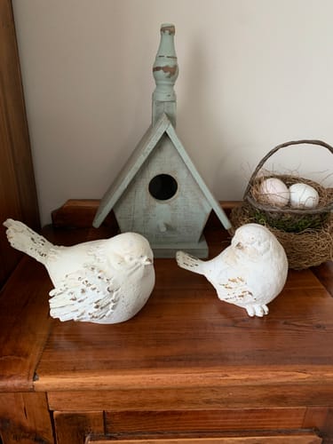 Customer's set of two Lucas French Provincial bird figurines displayed on a wooden surface with a birdhouse and basket.