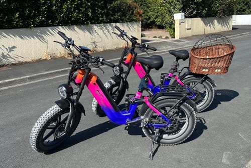 Customer's two CMACEWHEEL V20 e-bikes parked on a paved street, one with a rear basket.