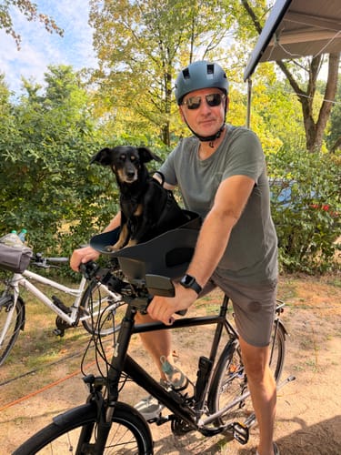 Customer's dog riding in a Comfort Seat Liner on a bike, enjoying the outdoor breeze.