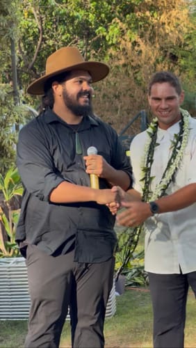 Customer's tan felt wide brim hat worn by a person outdoors while shaking hands with another person.