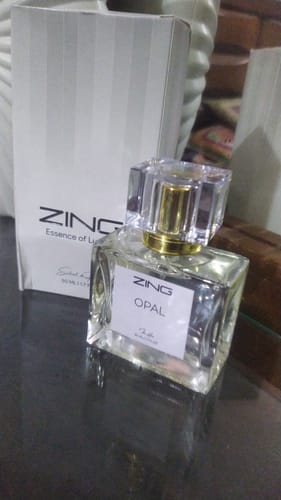 Customer's OPAL perfume bottle and white packaging box on a dark surface.
