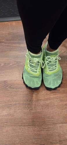 Customer's Smart I Pro barefoot shoes in light green, shown from a top-down view on a wooden floor.