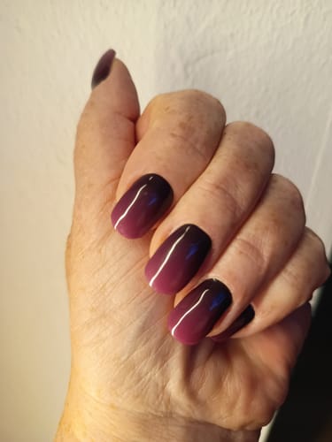 Customer's hand showing Twilight Ombré UV Gel Nail Wraps with a smooth black-to-purple gradient.