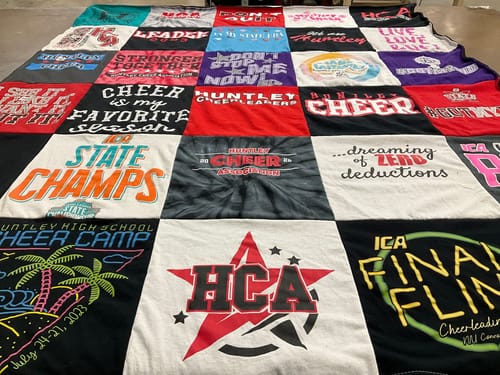 Customer's Project Repat T-Shirt Quilt featuring a grid of various colorful cheerleading themed t-shirt panels.