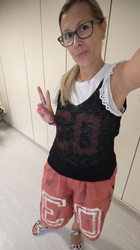 Customer's Bermuda Terracotta Nadia shorts, comfortable and stylish with graphic prints, worn in a casual indoor setting.