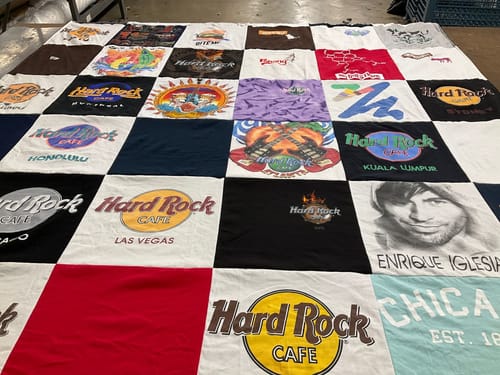 Customer's Project Repat T-Shirt Quilt featuring various Hard Rock Cafe shirt designs sewn together in a square pattern.
