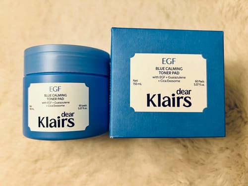 Customer's blue jar and matching box of Klairs EGF Blue Calming Toner Pads sitting on a textured surface.