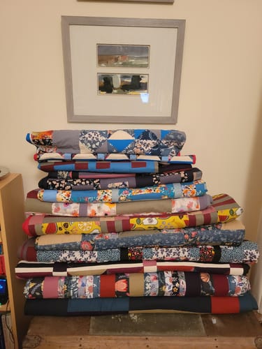 Customer's stack of colorful patterned quilts made with Premium Super Soft Wadding.