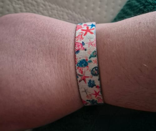 Customer's Trust the Journey Bracelet with sea turtle and starfish pattern, worn on the wrist.