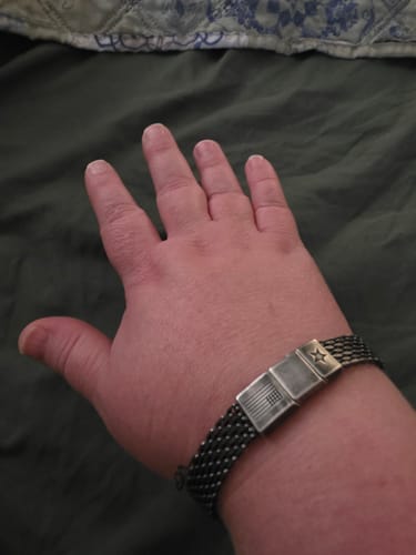 Customer's Never Surrender Patriot Bracelet with metallic flag design worn on a person's wrist.
