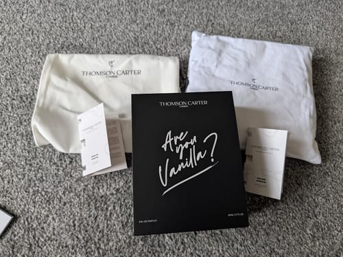 Customer's Are You Vanilla? box with two white branded fabric bags and product inserts on a gray carpet.