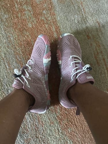 Customer's Smart II barefoot shoes in mauve knit, worn on feet over patterned carpet.