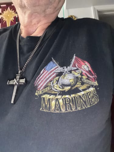 Customer's Nailed to the Cross necklace worn on a person wearing a Marines graphic t-shirt.