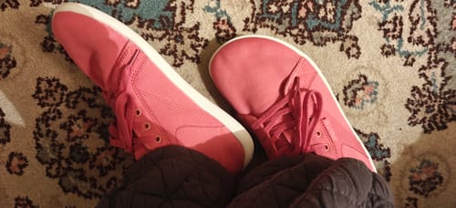 Customer's pink Luck I Barefoot Shoes worn inside on a patterned rug.