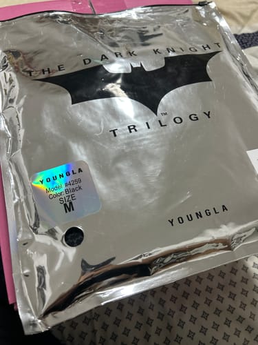 Customer's Batman Compression Tees in shiny silver packaging with The Dark Knight Trilogy branding.