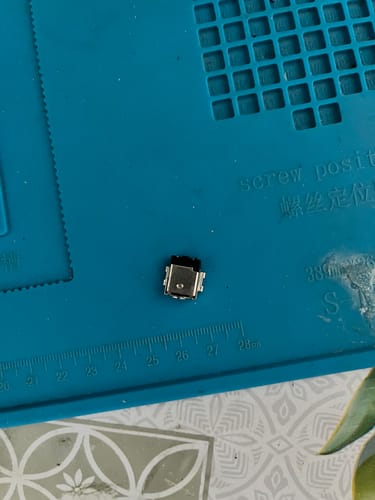 Customer's metallic DC Jack d’alimentation for laptop placed on a blue work mat.