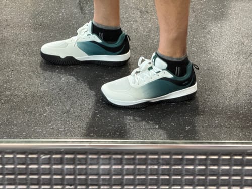 Customer's CUURT Muuv court shoes in white and dark green worn outdoors with grey socks.