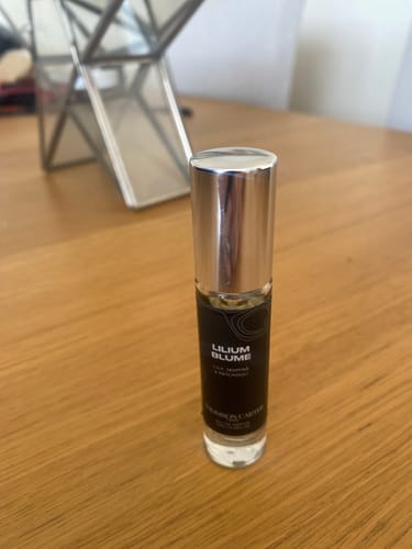 Customer's Lilium Blume Eau de Parfum bottle with a metallic cap sitting on a wooden table.