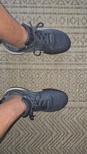 Customer's gray CUURT Muuv court shoes being worn on a textured indoor floor.