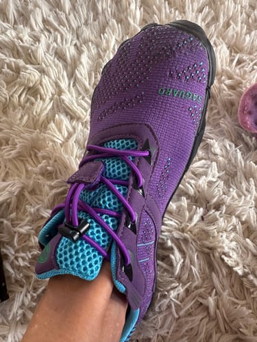 Reviewer's purple Free I barefoot shoe with blue mesh lining on a fuzzy white rug