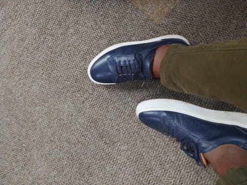 Customer's blue Lufiano lace-up shoes worn on carpeted floor, showing clean white soles.
